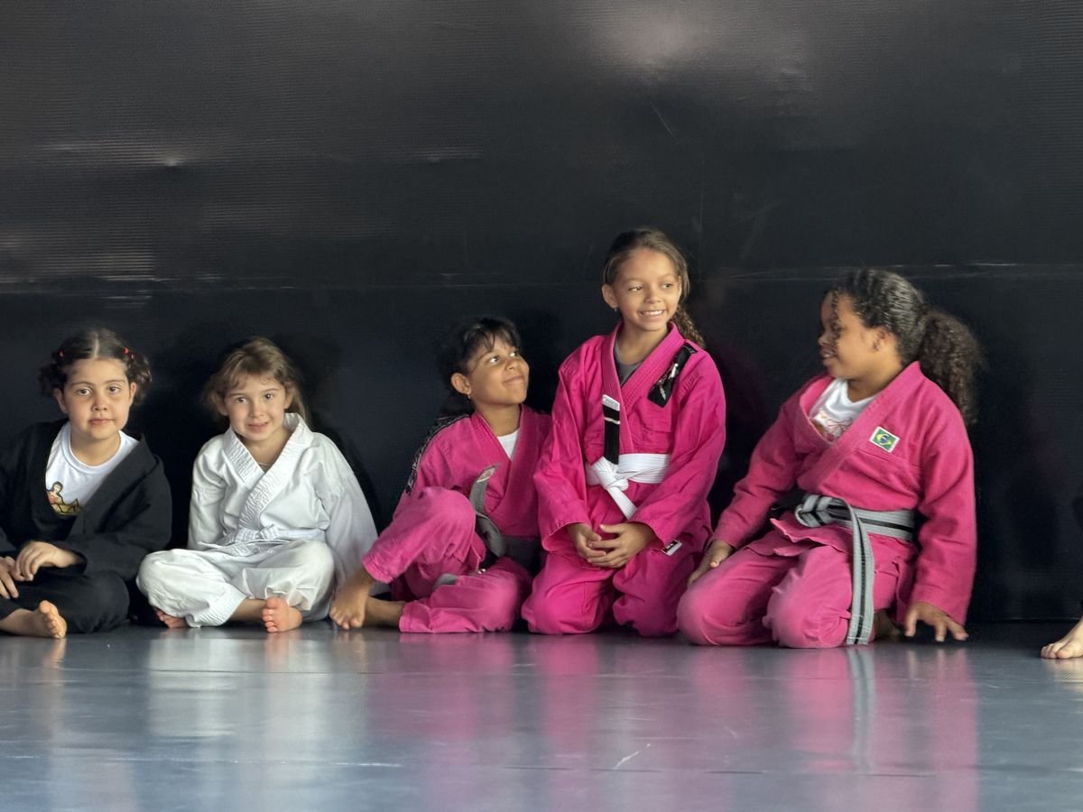 Alunas do Jiu Jitsu Kids sentadas no tatame