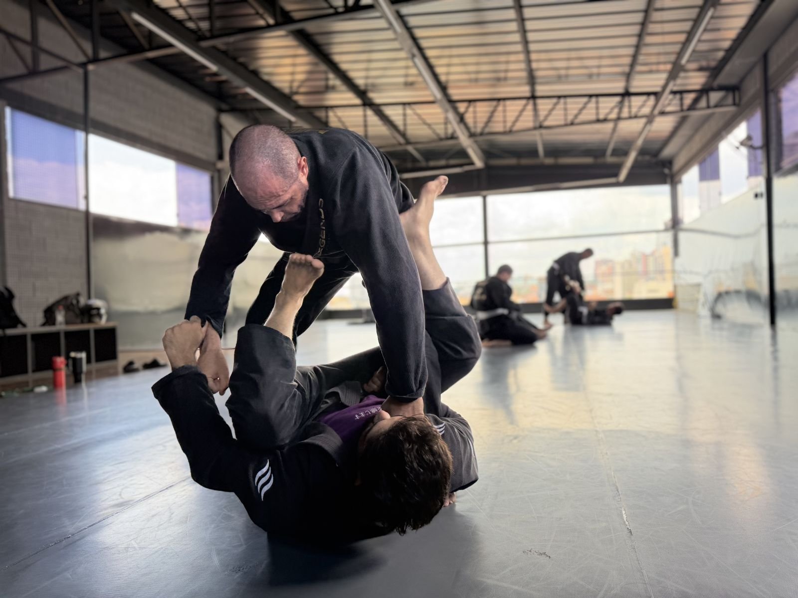 Treino no tatame com janelas amplas ao fundo
